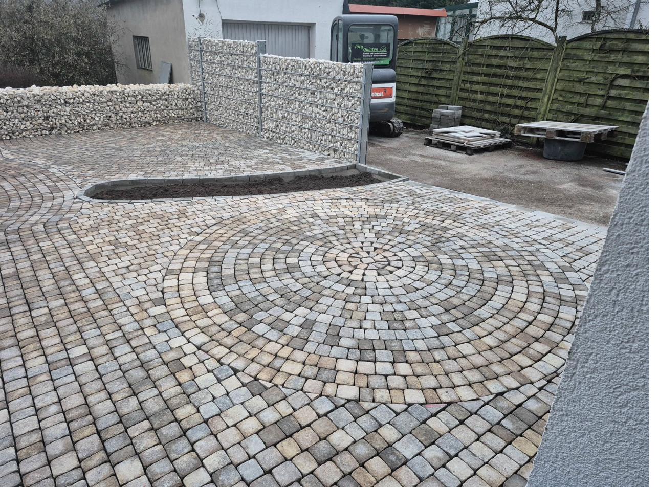 Kreisförmiges Pflastermuster mit Gabionenwand